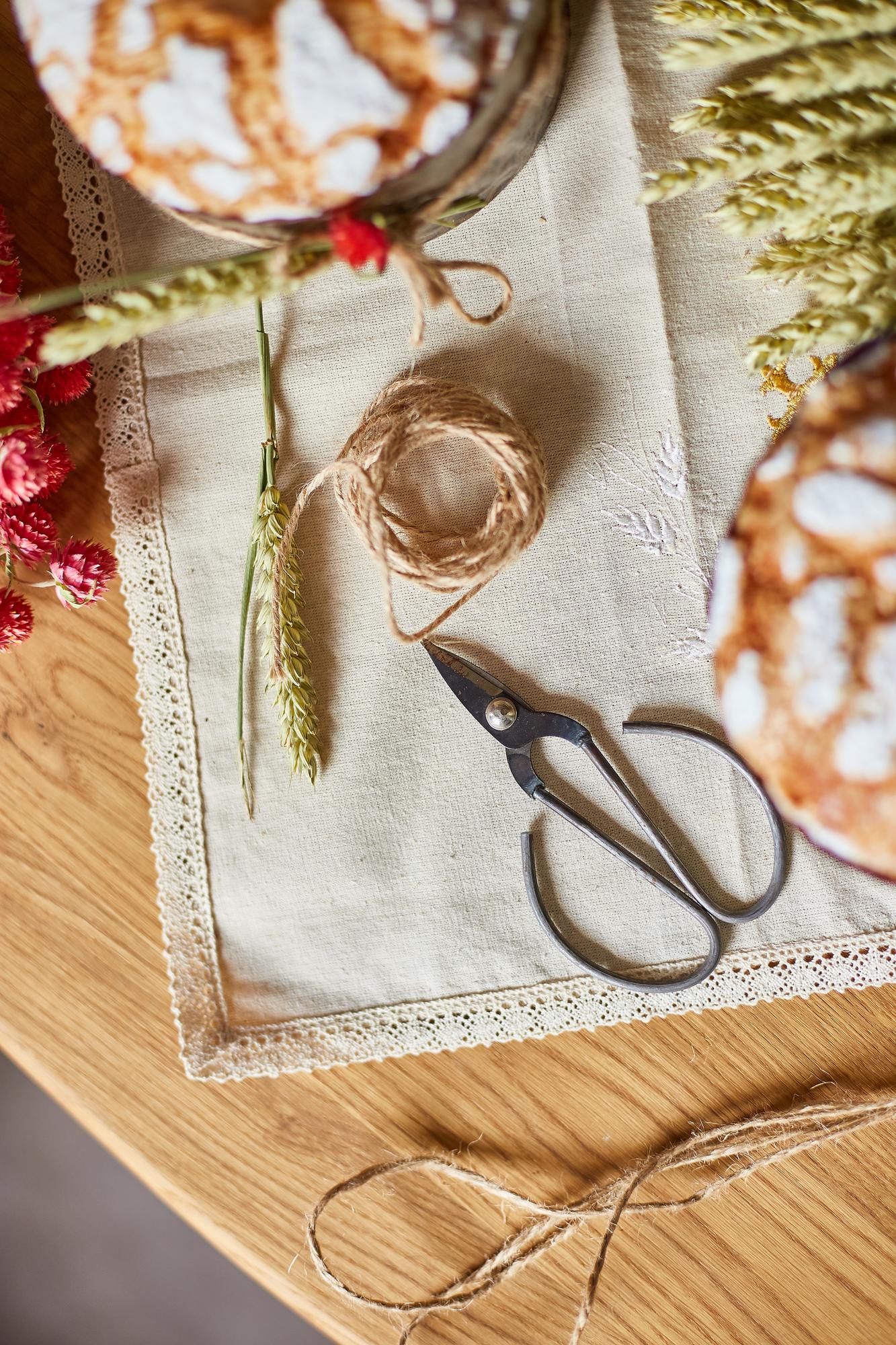 Large editorial shot: embroidered linen on wooden table